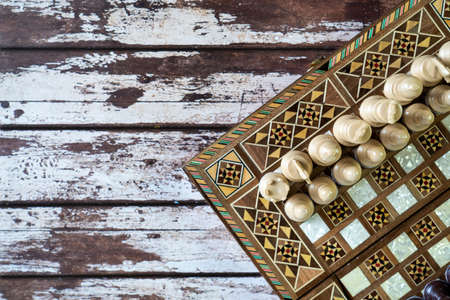 Top view of a chess game on old peeled of colored wooden tableの写真素材