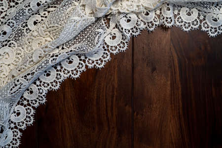 White hand made crocheted coaster lace doily on wood table.の写真素材