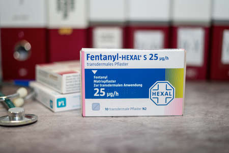 Drug box of  Fentanyl containing fentanil for treatment of severe pain,advanced-stage cancer  on a table and in the background different medical books.のeditorial素材