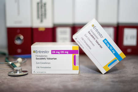 A Drug box of  Entresto containing Sacubitril and Valsartan for treatment of heart failure on a table and in the background different medical books.のeditorial素材