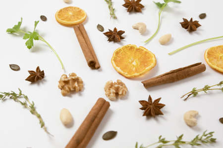 Fresh dried herbs  ,citrous orange slices , thyme cinnamon ,anise, nuts  setup with flat lay on white wooden table.tree shape arrangeの写真素材