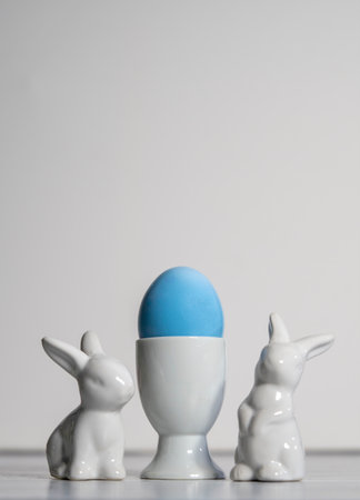 Porcelain Easter bunnies Porcelain Egg Cups with Blue Easter egg.On a white background .