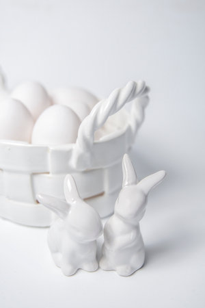 White porcelain Easter bunny and egg corp with white eggs on white backgroundの写真素材