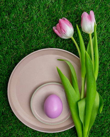Pink colored tulips with a pink Easter egg in plate.