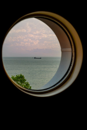 A view from the porthole window of a cruise ship, showing a shipの写真素材