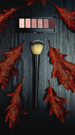 Makeup Blusher powder and makeup  brush with fall red brown  leaves on black wooden backgroundの写真素材