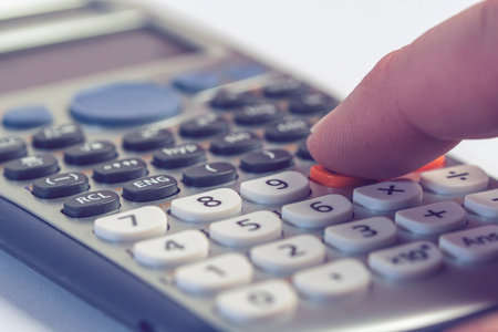 Calculator and human finger on it calculating.Macro photographyの写真素材
