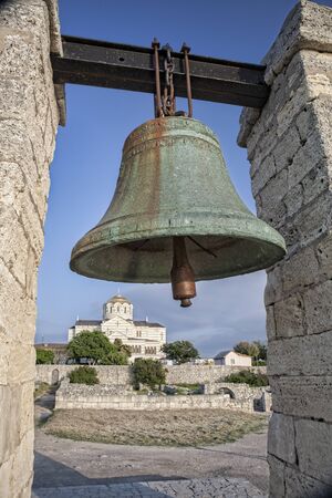 Bronze bell on the background of Vladimirsky cathedral in Chersonesos in Crimea, Ukraineの写真素材