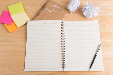 blank notebook with pen and pencil on wooden table, business concept