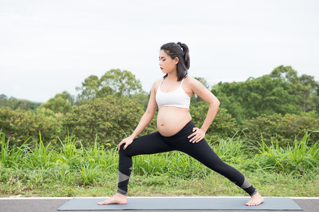 Pregnant woman doing exercise in relaxation on yoga pose. The concept of health and sportの写真素材