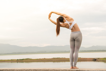 Young sportswoman stretching and preparing to yogaの写真素材
