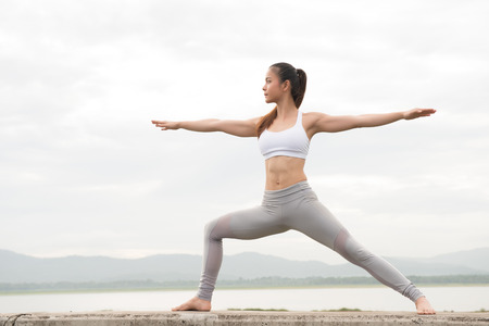 Young woman doing yoga on the lakeの写真素材