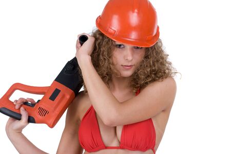 Closeup portriet of beautiful curly girl in orange helmet with perforator drillの写真素材