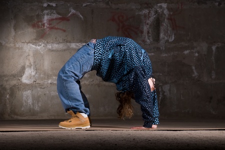 Hip hop girl dancing in modern style over urban grey brick wallの写真素材