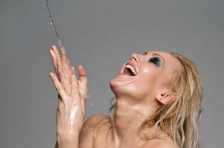 Close up portrait of blond woman that play with waterの写真素材