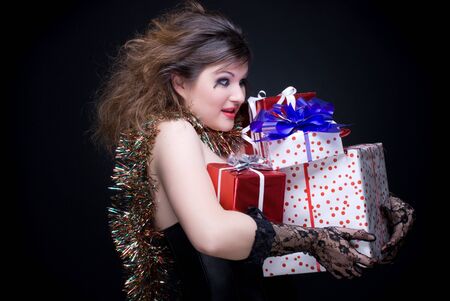 Closeup portrait of beautiful girl with red lips, tinsel and present on black