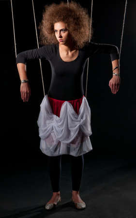 Beautiful doll women with control line standing on blackの写真素材