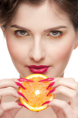 Close up portrait of young beauty woman with fruit bodyart and piece of juicy orange . Isolated on white.の写真素材