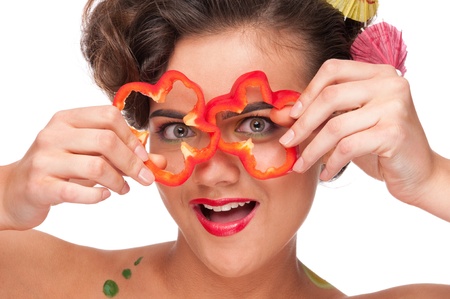 Close up portrait of young emotional beauty woman with pieces of red pepper. Perfect skin! Isolated on white.の写真素材
