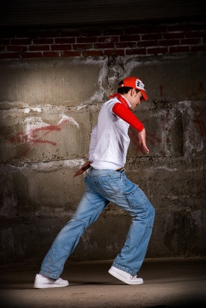 Hip hop men dancing in modern style over grey brick wallの写真素材