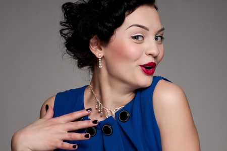 Closeup beautiful emotional glamour woman with red lips. Blue dress, black nails and beads. Vogueの写真素材