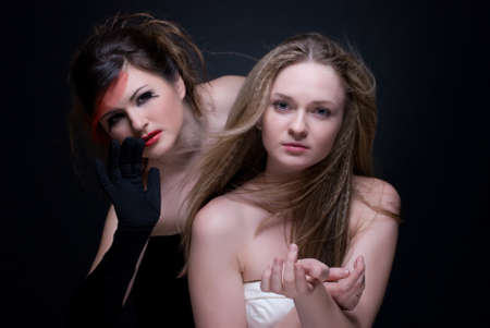 Closeup portrait of two girls: black & white or good & evilの写真素材