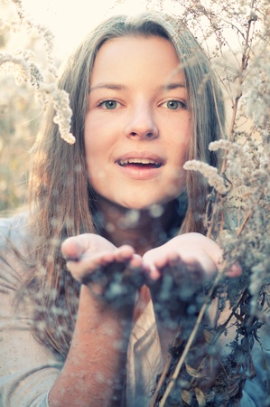 Beautiful young woman in casual wear over evening autumn nature landscapeの写真素材