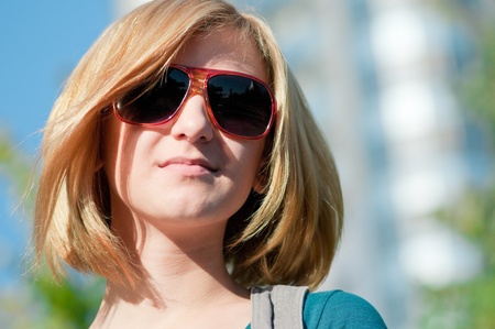 Close up of young casual cheerful woman walking in city parkの写真素材