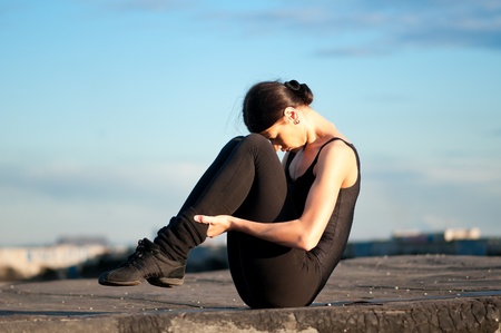 dancing woman in modern pilates style over urban city landscape and blue sky. Yogaの写真素材