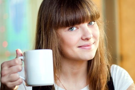 A young attractive woman sitting in a cafe with a coffeの写真素材