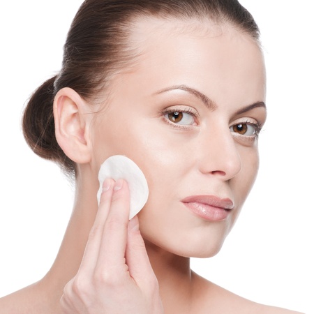 Closeup portrait of young beautiful woman with perfect skin. Applying clean sponge. Isolatedの写真素材