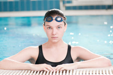 Portrait of a young woman in goggles in swimming poolの写真素材