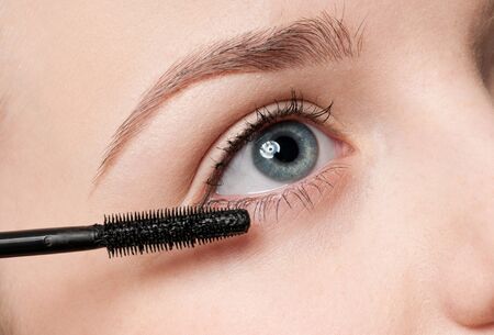 Beautiful woman applying mascara on her eyelashesの写真素材