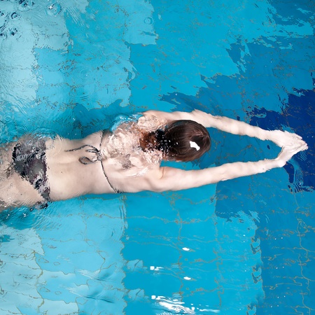 Swimmer woman is diving in a swimming poolの写真素材