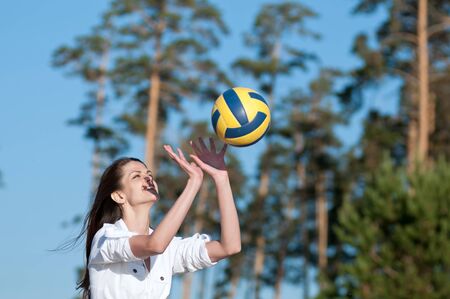 Young beautiful woman playing volleyball on beachの写真素材