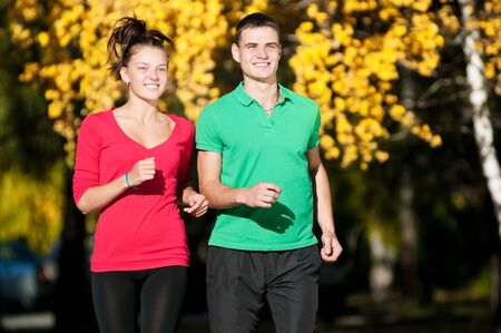 Young fitness couple of man and woman run in park の写真素材