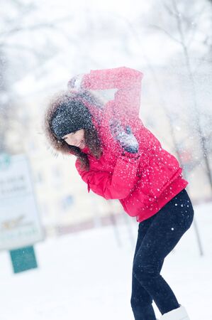 Happy young woman plays with a snow outdoor. Winter dayの写真素材