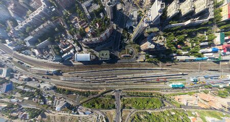 Aerial city view with crossroads on roads, houses and buildings, parks and parking lots, bridges
