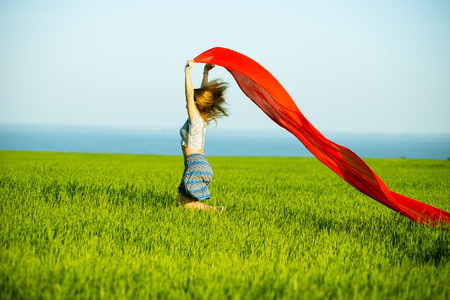 Young lady runing with tissue in green field. Beautiful happy woman walking in the summer rural meadow. Beautiful fit tan girl. Sexy slim model caucasian ethnicity outdoors.の写真素材