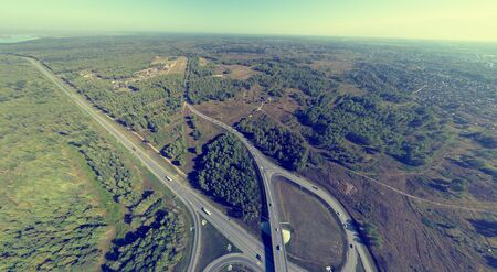 Aerial city view with crossroads and roads, houses, buildings, parks and parking lots, bridges. Copter shot. Panoramic image.の写真素材