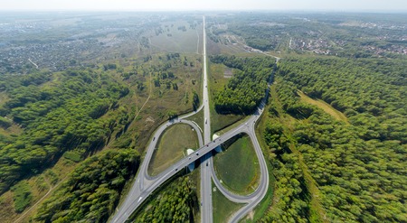 Aerial city view with crossroads and roads, houses, buildings, parks and parking lots, bridges....