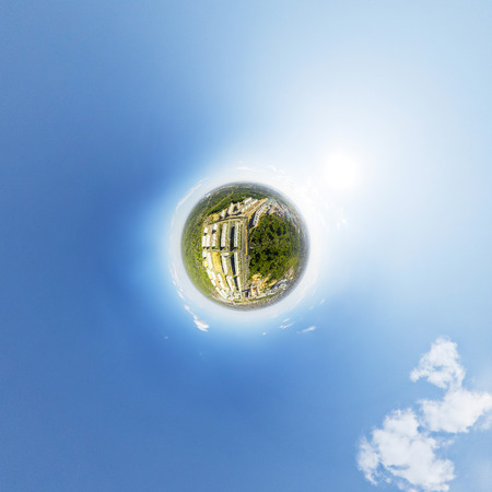 Aerial city view with crossroads and roads, houses, buildings, parks and parking lots, bridges. Copter shot. Little planet sphere mode.の写真素材