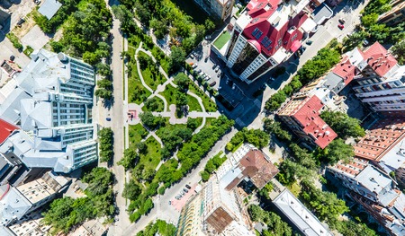 Aerial city view with crossroads, roads, houses, buildings, parks and parking lots. Copter drone helicopter shot. Panoramic wide angle image.の写真素材