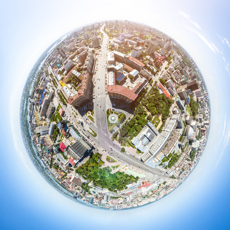 Aerial city view with roads, houses and buildings.