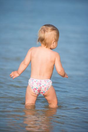 Cute baby playing on the sandy beach and in sea water.の写真素材