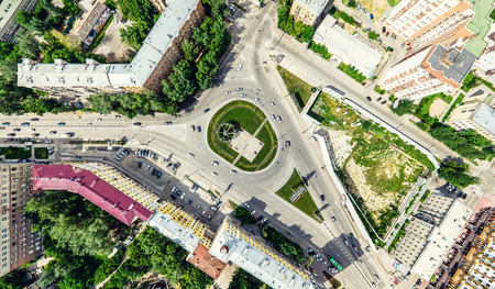 Aerial city view with crossroads and roads, houses, buildings, parks and parking lots. Sunny summer panoramic imageの写真素材