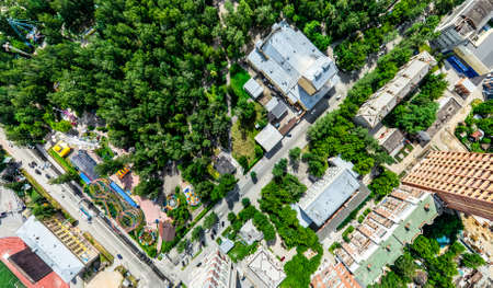 Aerial city view with crossroads and roads, houses, buildings, parks and parking lots. Sunny summer panoramic imageの写真素材