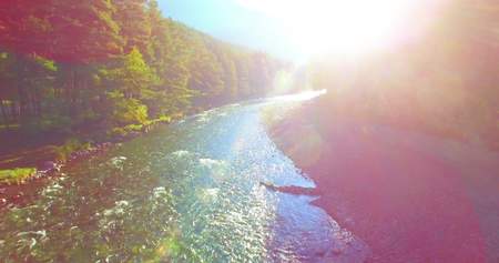 Mid air flight over fresh and clean mountain river at sunny summer morningの写真素材