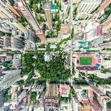 Aerial city view with crossroads and roads, houses, buildings, parks and parking lots. Sunny summer panoramic imageの写真素材