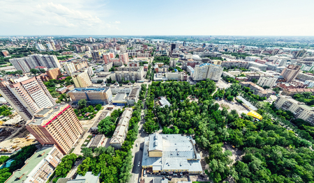 Aerial city view with crossroads and roads, houses, buildings, parks and parking lots. Sunny summer panoramic imageの写真素材